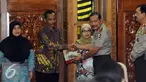 Kapolri, Jenderal Polisi Badrodin Haiti (kedua kanan) menyerahkan bantuan kepada keluarga korban teror Jakarta di Mabes Polri, Jakarta, Jumat (22/1/2016). Kapolri menegaskan hal ini merupakan bentuk kepedulian polri. (Liputan6.com/Helmi Fithriansyah)