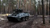 Sebuah kendaraan lapis baja yang hancur terlihat di base camp Rusia yang kosong di dekat Buda-Babynetska, utara Kiev, pada 5 April 2022, beberapa hari setelah pasukan Rusia mundur. (RONALDO SCHEMIDT / AFP)