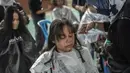 Warga saat potong rambut gratis di Masjid Muhammad Cheng Hoo, Surabaya, Jawa Timur, Senin (18/4/2022). Kegiatan berbagi dalam bulan Ramadhan yang digelar Baksose Suroboyo dan Ngaji Komunitas Salon (Ngasal) Surabaya itu diikuti sekitar 450 orang. (AFP/Juni Kriswanto)