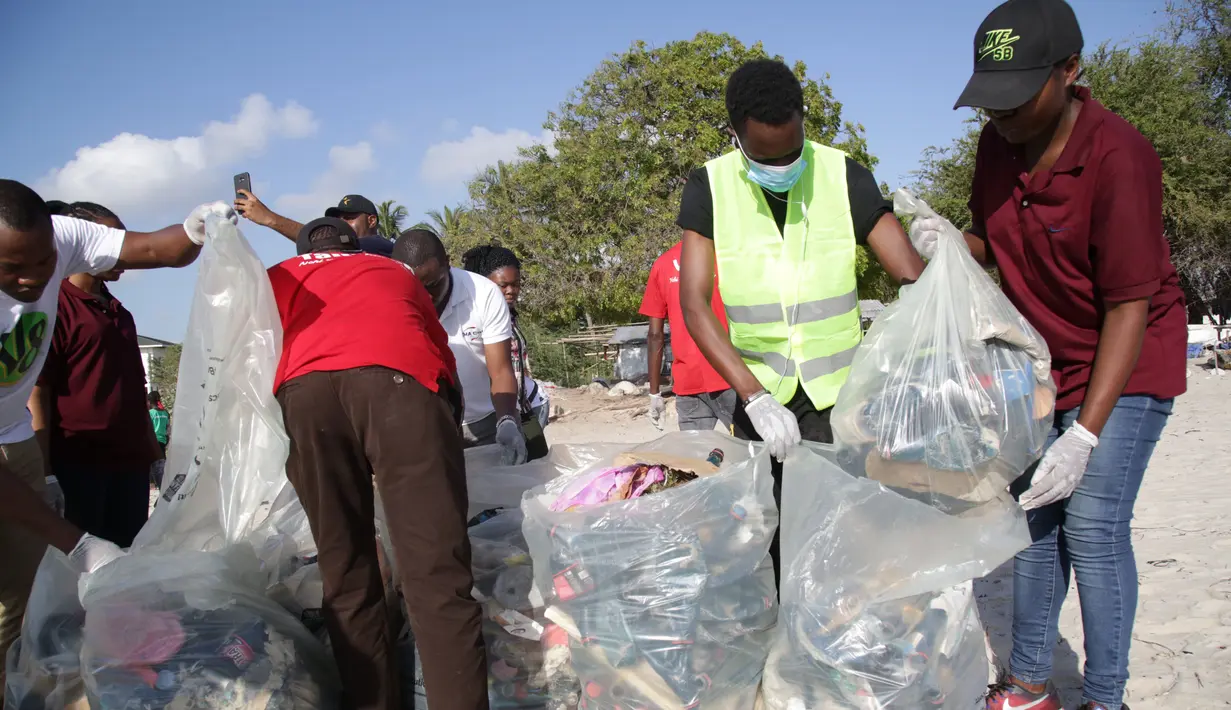 Para sukarelawan mengumpulkan sampah di sepanjang Pantai Kawe di Dar es Salaam, Tanzania (19/9/2020). Ratusan orang di seluruh kota tersebut berpartisipasi dalam upaya pembersihan sampah di pantai untuk memperingati Hari Bersih-Bersih Sedunia. (Xinhua)