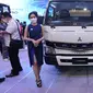 Model berdiri di depan mobil niaga listrik Fuso “eCanter" pada pameran otomotif Gaikindo Indonesia International Auto Show (GIIAS) 2022 di ICE BSD, Tangerang, Kamis (11/8/2022). (Liputan6.com/Fery Pradolo)