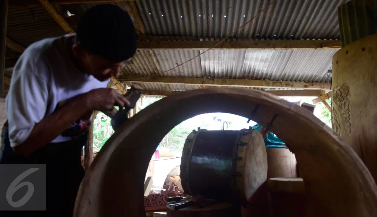 Seorang pengrajin menyelesaikan ukiran di atas kayu untuk dijadikan bedug di Desa Bleder, Ngasinan, Grabag, Magelang, Jawa Tengah, Jumat (3/6). Menjelang Ramadan, pengrajin bedug mulai kebanjiran order dari berbagai kota di Indonesia (Liputan6.com/Gholib)