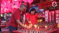 Warga keturunan Tionghoa menyalakan lilin saat sembahyang Vihara Amurva Bhumi, kawasan Karet Semanggi, Jakarta, Jumat (24/1/2020) malam. Ibadah tersebut dalam rangka menyambut Tahun Baru Imlek 2571/2020. (Liputan6.com/Herman Zakharia)