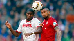 Gelandang Bayern Munchen, Arturo Vidal duel udara dengan pemain FC Koln, Anthony Modeste pada laga Bundesliga di Stadion Allianz Arena, Jerman, Sabtu (24/10/2015). (Reuters/Michael Dalder)
