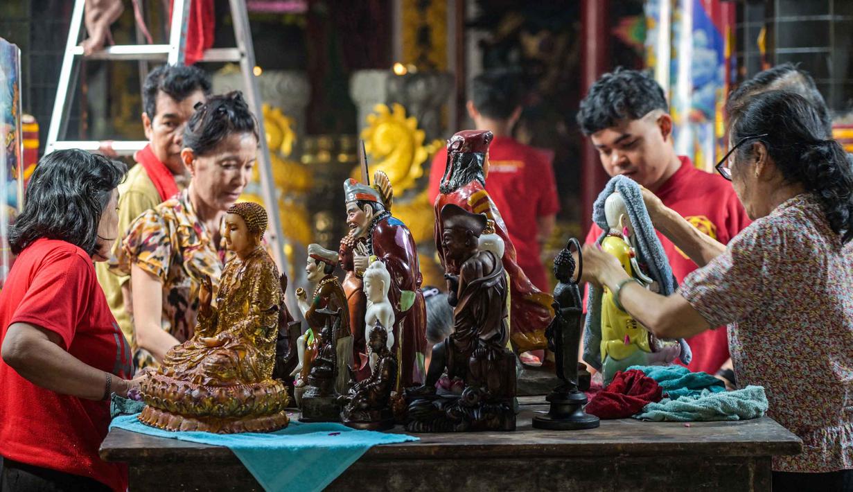 Tradisi bersih-bersih rupang atau patung dewa (para suci) mewarnai persiapan perayaan Tahun Baru Imlek 2577 Kongzili di Kuil Hong San Ko Tee, Surabaya, Jawa Timur, pada Rabu 11 Februari 2026. Tampak dalam foto, para sukarelawan membersihkan patung-patung dewa di Kuil Hong San Ko Tee, Surabaya, Jawa Timur, pada Rabu 11 Februari 2026. (JUNI KRISWANTO/AFP)