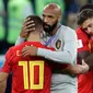 Asisten pelatih Belgia, Thierry Henry menghibur Eden Hazard pada akhir babak semifinal Piala Dunia 2018 melawan Prancis di Stadion St. Petersburg, Selasa (10/7). Upaya Belgia tampil di final berakhir usai takluk 0-1 dari Prancis. (AP/Petr David Josek)