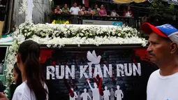 Sebuah mobil yang membawa jenazah Kian Loyd delos Santos diiringi para demonstran di Caloocan, Filipina (26/8). Dalam pemakaman itu lebih dari lima ribu orang berduka saat mengiringi pemakaman Kian Loyd. (AP Photo/Bullit Marquez)
