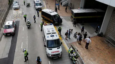 Polisi bersenjata lengkap menjaga mobil yang membawa mantan bankir Inggris, Rurik Jutting memasuki Pengadilan Tinggi di Hong Kong, Tiongkok, Selasa (25/10). Rurik didakwa atas pembunuhan dua warga negara Indonesia (WNI) di Hong Kong. (Reuters/Bobby Yip)