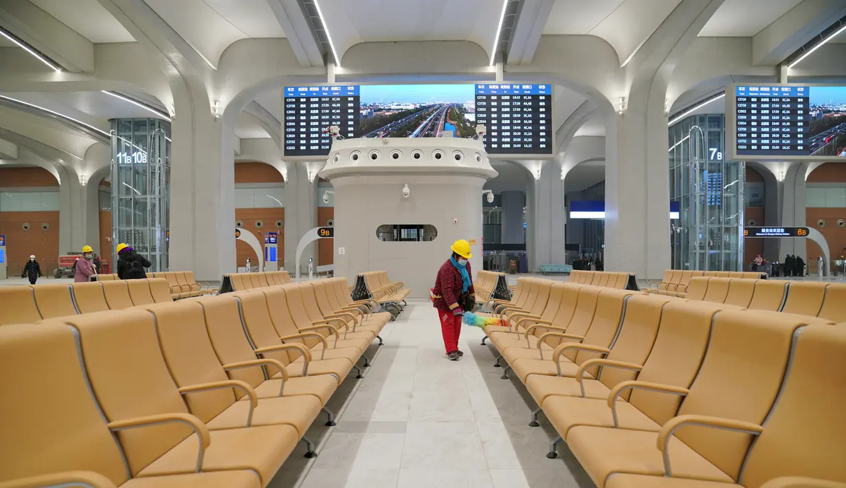 Para pekerja membersihkan kursi di ruang tunggu Stasiun Kereta Xiongan, yang merupakan bagian dari jalur kereta antarkota Beijing-Xiongan, di Kawasan Baru Xiongan di Provinsi Hebei, China utara (23/12/2020). Stasiun ini menampilkan pola dan lapisan yang dicetak menggunakan bekisting. (Xinhua/Mu Yu)