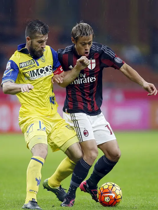 Gelandang AC Milan, Keisuke Honda (kanan) berusaha melewati bek Chievo, Bostjan Cesar pada laga serie A di stadion San Siro, Italia (28/10/2015). AC Milan menang atas Chievo dengan skor 1-0. (REUTERS/Alessandro Garofalo)