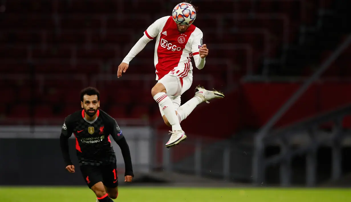 Bek Ajax Amsterdam, Nicolas Tagliafico mengontrol bola diawasi penyerang Liverpool, Mohamed Salah pada pertandingan pertama Grup D Liga Champions 2020 di Johan Cruijff Arena, Kamis (22/10/2020) dini hari WIB. Liverpool susah payah menang tipis 1-0 di kandang Ajax. (AP Photo/Peter Dejong)