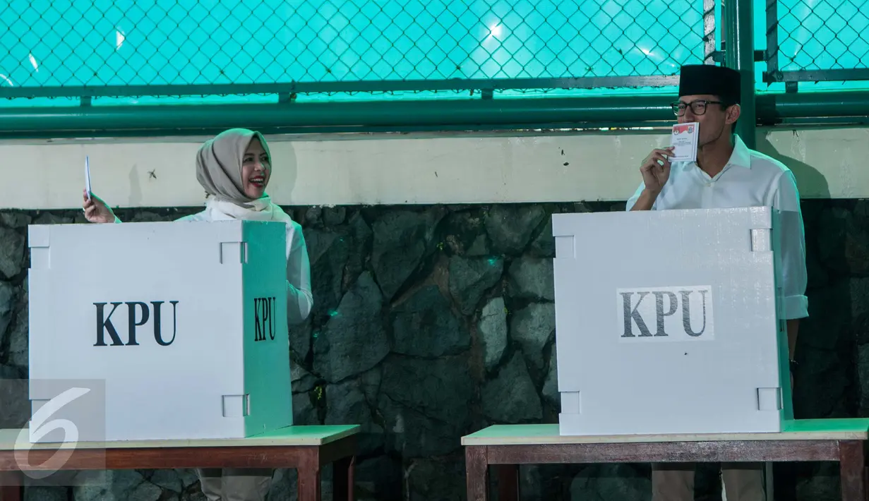 Cawagub DKI Sandiaga Uno bersama istri menunjukkan surat surat usai mencoblos pada Pilkada DKI 2017 di TPS 01 Kelurahan Selong, Kebayoran Baru, Jakarta Selatan, Rabu (15/2). Sandi datang ke TPS dengan ditemani keluarganya. (Liputan6.com/Gempur M Surya)