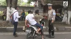 Tiga orang remaja dicegat oleh polisi karena tidak menggunakan helm saat mengendarai motor.