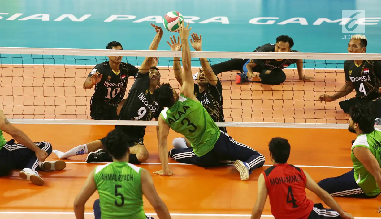 Tim voli duduk putra Indonesia menghadang smash pemain Iraq saat berhadapan pada pertandingan Asian Para Games di GBK, Jakarta, Senin (8/10). Indonesia kalah dari Iraq dengan skor 25-11, 25-10, dan 25-10. (Merdeka.com/Imam Buhori)