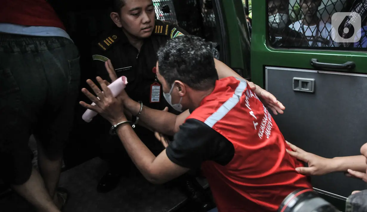 Tersangka lainnya mengenakan rompi merah Kejaksaan saat menuju mobil tahanan usai pelimpahan tahap II kasus narkoba di Kejaksaan Negeri Jakarta Barat, Rabu (11/1/2023). Penyidik Ditresnarkoba Polda Metro Jaya resmi melimpahkan berkas perkara kasus narkoba mantan Kapolda Sumatera Barat Irjen Pol Teddy Minahasa dan sejumlah tersangka ke Kejari Jakarta Barat. (merdeka.com/Iqbal S Nugroho)