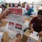 Relawan menunjukkan surat suara Pilpres 2019 yang dilipat di Gudang KPU, Cibinong, Bogor, Kamis (7/3). Jutaan kertas suara tersebut nantinya akan didistribusikan ke 40 kecamatan di wilayah Kabupaten Bogor. (merdeka.com/Arie Basuki)