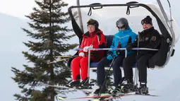 Presiden Rusia Vladimir Putin (kiri) dan Presiden Belarusia Alexander Lukashenko (kanan) menaiki lift ski saat akan bermain ski di Krasnaya Polyana dekat resor Laut Hitam Sochi, Rusia, Rabu (13/2). (Sergei Chirikov/Pool Photo via AP)