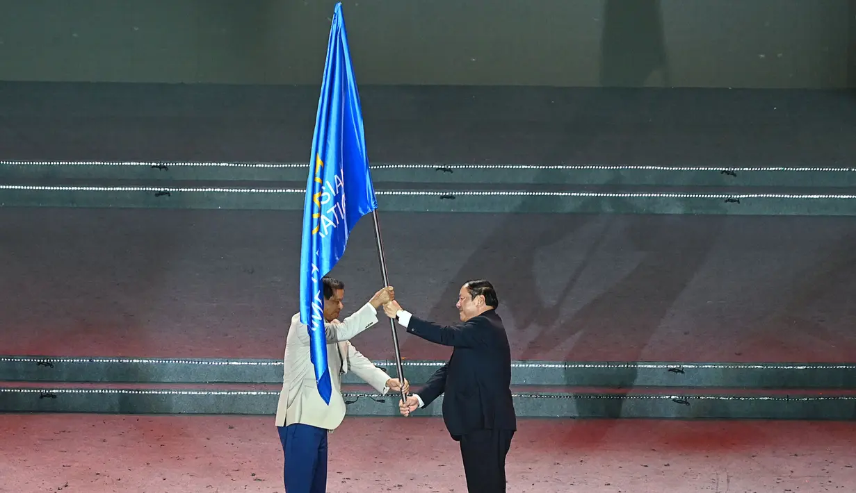 National Olympic Committee (NOC) Vietnam lalu menyerahkan bendera ASEAN kepada NOC Kamboja yang akan menjadi tuan rumah SEA Games pada 2022. Panitia penyelenggara SEA Games 2021 (VIESGOC) lalu menyerahkan tongkat estafet pesta olahraga ASEAN ke Kamboja yang akan menjadi tuan rumah pada 2023. (AFP/Tang Chhin Sothy)