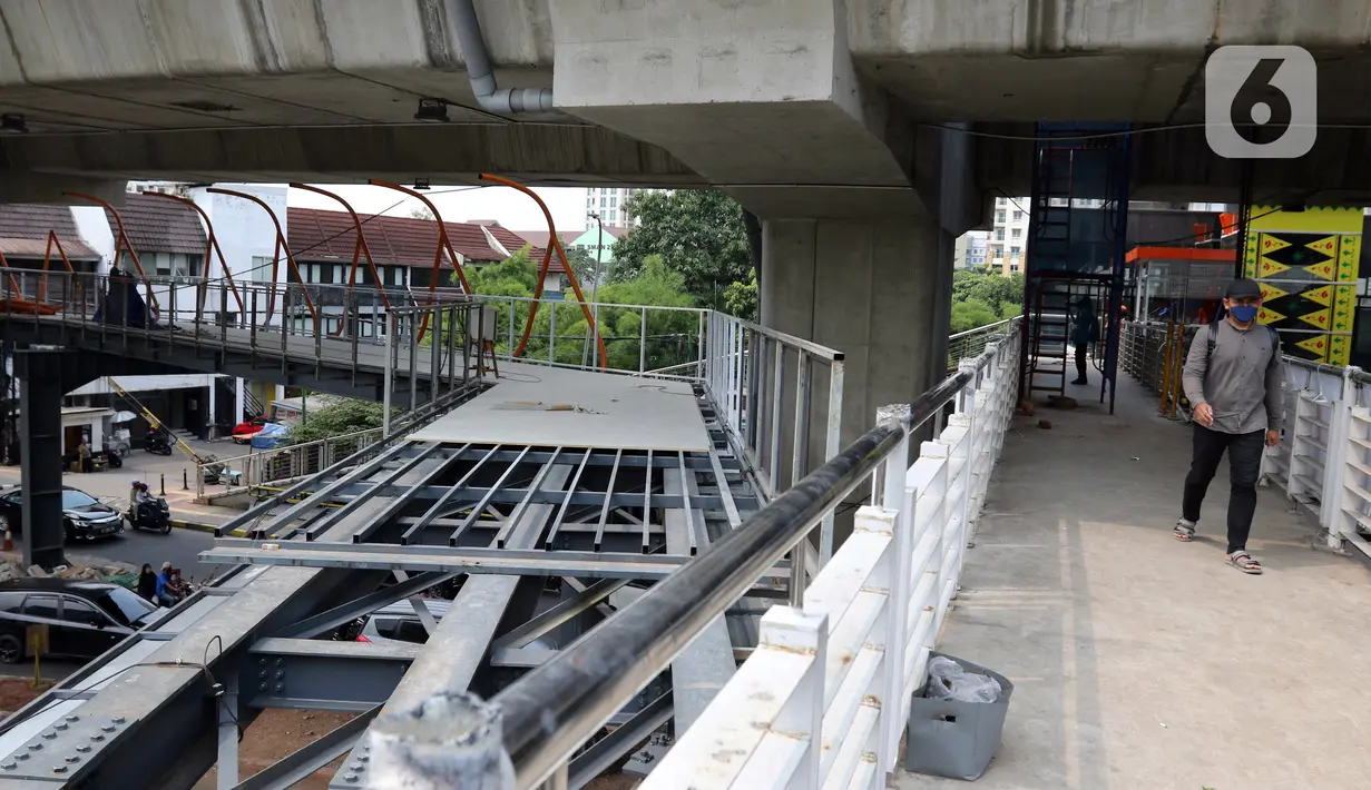 Pejalan kaki berjalan melintasi jembatan penyeberangan orang (skywalk) di kawasan Kebayoran Lama, Jakarta, Rabu (2/11/2022). Pengerjaan skywalk sepanjang 500 meter dengan desain cahaya artistik dan dilengkapi fasilitas lift nantinya mengintegrasikan Stasiun Kebayoran dengan Halte Transjakarta Koridor 8 dan Koridor 13. (Liputan6.com/Herman Zakharia)