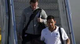Pemain Timnas Inggris, Frank Lampard (depan) dan Wayne Rooney berjalan menuruni tangga pesawat saat tiba di bandara Rio de Janeiro, Brasil, (8/6/2014). (REUTERS/Pilar Olivares)