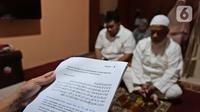 Warga mendengarkan khotbah saat melaksanakan salat Idul Fitri di kediamannya kawasan Mekarsari, Depok, Jawa Barat, Minggu (24/5/2020). Warga menjalankan salat Idul Fitri di rumah saat pandemi COVID-19. (Liputan6.com/Herman Zakharia)