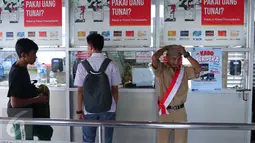Penumpang saat membeli tiket di Halte Trans Jakarta, Selasa (16/8).Petugas mengenakan pakaian tentara perjuangan tempo dulu untuk menyambut para penumpang. (Liputan6.com/Angga Yuniar)