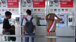 Penumpang saat membeli tiket di Halte Trans Jakarta, Selasa (16/8).Petugas mengenakan pakaian tentara perjuangan tempo dulu untuk menyambut para penumpang. (Liputan6.com/Angga Yuniar)