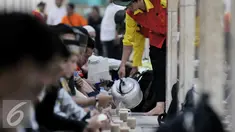 Petugas menuangkan minuman untuk berbuka kepada para jamaah yang hadir di Masjid Istiqlal, Jakarta (22/6/2015). Sekitar 3000 kotak makanan dan minuman dibagikan setiap harinya selama bulan Ramadan. (Liputan6.com/JohanTallo)