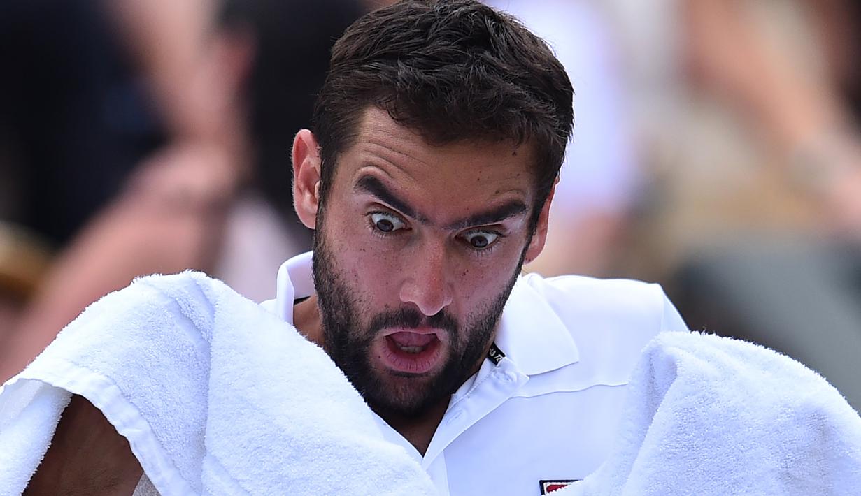 Mimik wajah Marin Cilic saat menggunakan handuk pada perempat final melawan Gilles Muller di The All England Lawn Tennis Club, London, (11/7/2017). (AFP/Glyn Kirk)
