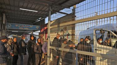 Pekerja Palestina memasuki van mini di stasiun terakhir di Beit Hanun di Jalur Gaza utara, sebelum mencapai Israel melalui penyeberangan Erez untuk bekerja (23/2/2022). Israel mengatakan akhir tahun lalu bahwa 3.000 warga Gaza tambahan akan diizinkan masuk Israel untuk bekerja. (AFP/Mohammed Abed)