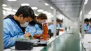 Aktivitas pekerja di sebuah pabrik elektronik di wilayah Xiushan, Chongqing, China barat daya, Jumat (27/2/2020). Kegiatan produksi dan kehidupan sehari-hari warga berangsur normal berkat upaya pengendalian virus corona COVID-19 yang efektif di Xiushan. (Xinhua/Liu Chan)