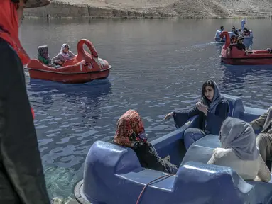 Wisatawan duduk di atas perahu dayung untuk berkendara di Danau Band e-Amir, Provinsi Bamiyan, 4 Oktober 2021. Danau Band-e Amir yang memiliki perairan biru menakjubkan disebut juga sebagai Grand Canyon Afghanistan. (BULENT KILIC/AFP)