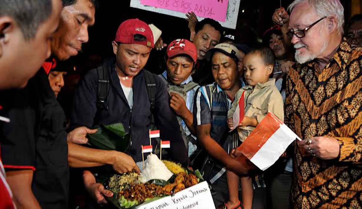Para pendukung Jokowi tampak memotong tumpeng di Bundaran HI sebagai tanda syukur atas pencalonan Jokowi (Liputan6.com/Johan Tallo)