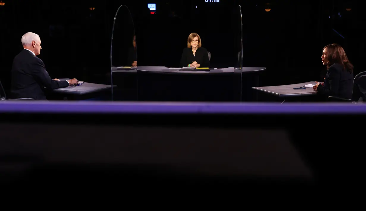 Wakil Presiden Mike Pence menyimak penantangnya, Senator Kamala Harris dari Partai Demokrat berbicara pada Debat cawapres Amerika Serikat di Kingsbury Hall, Universitas Utah di Salt Lake City, Rabu (7/10/2020).  Dalam debat, Pence dan Harris duduk dan diberi sekat kaca. (Justin Sullivan/Pool via AP)