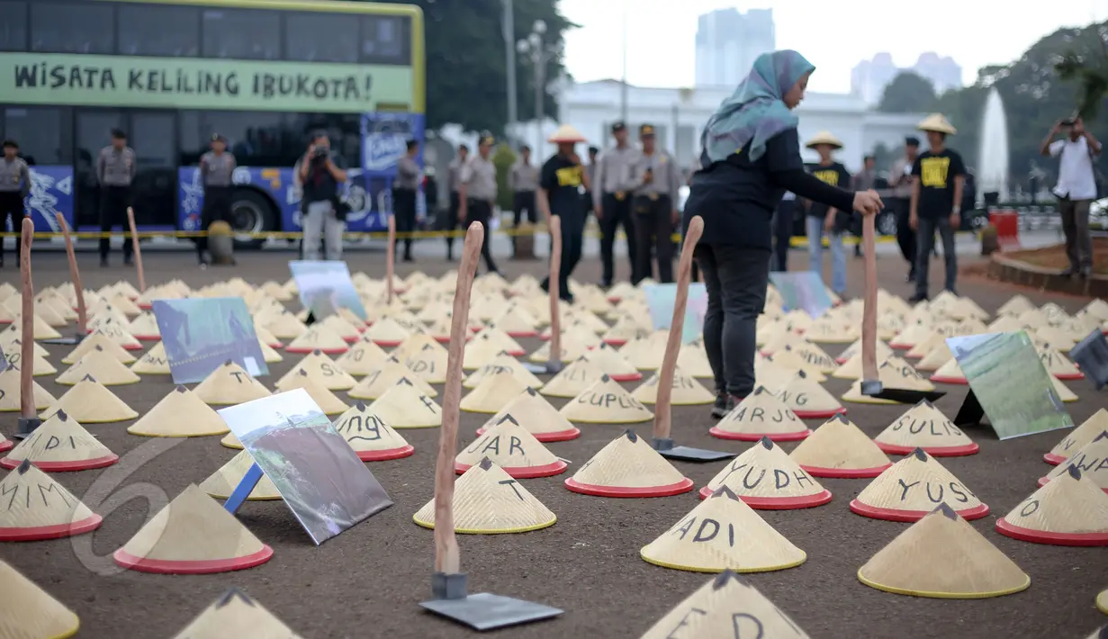 Warga Batang, Jawa Tengah membawa cangkul dan caping saat aksi di depan Istana Merdeka, Jakarta, Rabu (3/6/2015). Massa menuntut Presiden Jokowi menghentikan rencana pembangunan PLTU batubara di Batang. (Liputan6.com/Faizal Fanani)