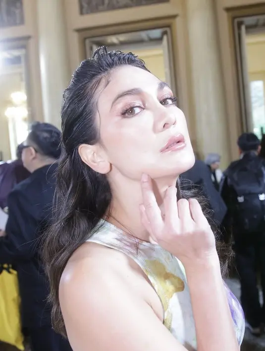 Wajahnya pun dipoles dengan teknik clean makeup namun terlihat glam. MUA Elena Ershova mengaplikasikan lipstik nude glossy, dengan riasan mata mengenakan blush on nude shimmer dan eyeliner tipis.[@lunamaya]