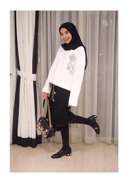 Zaskia Sungkar hobi banget bergaya monokrom. Kali ini ia memakai midi skirt dan stocking yang berwarna hitam. Dipadukan dengan blouse putih dan hijab hitam, Zaskia tampak stylish banget. (Instagram/zaskiasungkar)