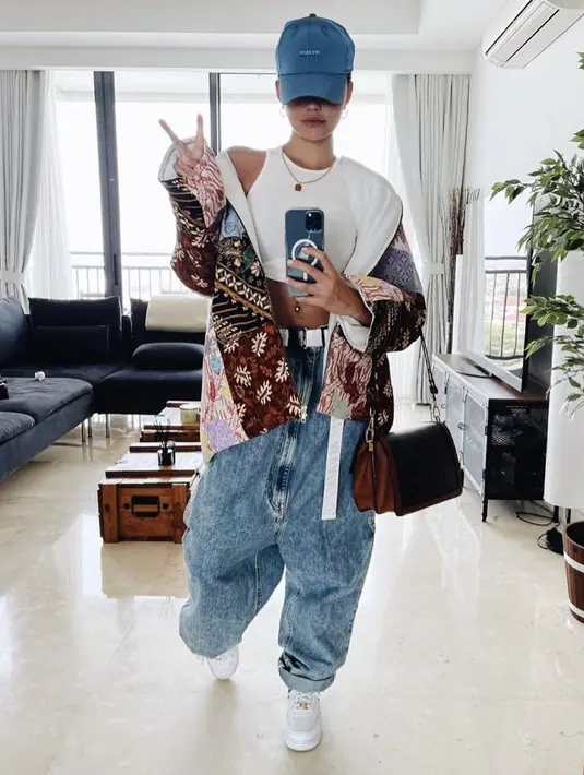 Agnez Mo mengenakan topi cap baseball biru dari koleksi Adidas Ivy Park seharga Rp568 ribuan. Dipaduka denhan tank top crop top dan jaket bernuasa batik. @agnezmo. 