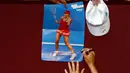 Maria Sharapova menandatangani poster bergambar dirinya usai memenangkan pertandingan ketiga putaran melawan Lauren Davis di turnamen Australia Open 2016 di Melbourne Park, Australia, (22/1). Sharapova menang 6-1, 6-7(5), dan 6-0. (REUTERS/Jason Reed)