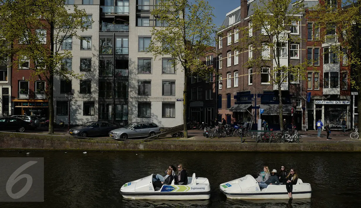 Warga menaiki perahu saat melintasi kanal di kawasan Amsterdam, Belanda (April 2017). Meskipun pada abad ke-19 kotor dan dipenuhi limbah, kini kanal-kanal di Belanda menjadi salah satu objek wisata terkenal di dunia. (Liputan6.com/Immanuel Antonius)