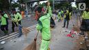 Petugas kebersihan membersihkan sampah sisa pendemo usai unjuk rasa buruh di kawasan Patung Kuda, Jakarta, Kamis (22/10/2020). Sebelumnya, buruh dari berbagai elemen berunjuk rasa menolak pengesahan Omnibus Law UU Cipta Kerja. (Liputan6.com/Faizal Fanani)