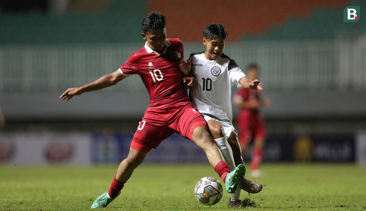 <p>Pemain Timnas Indonesia U-17,&nbsp;Muhammad Nabil Asyura (kiri) berebut bola dengan pemain Timnas Guam U-17, Riku Ngeschekle Meyar dalam pertandingan Grup B Kualifikasi Piala Asia U-17 2023 yang berlangsung di Stadion Pakansari, Bogor, Senin (3/10/2022). (Bola.com/Bagaskara Lazuardi)</p>