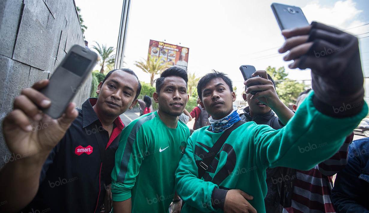 Pemain timnas Indonesia, Andik Vermansah, diserbu warga yang mengajaknya foto bareng usai latihan jelang laga persahabatan melawan Malaysia di Hotel Alana, Solo, Jawa Tengah, Selasa (6/9/2016). (Bola.com/Vitalis Yogi Trisna) 