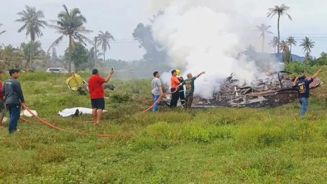 Petugas penyelamat dan pemadam kebakaran membantu memadamkan api setelah helikopter polisi jatuh di Distrik Muang, Prachuap Khiri Khan, pada Sabtu sore (24/5/2025). (Facebook Fire & Rescue Thailand)