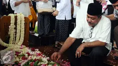Gubernur Banten, Rano Karno menatap makam ibunya, Lily Soekarno M Noor usai pemakaman di TPU Tanah Kusir Jakarta, Senin (7/12/2015). Ibunda Rano Karno wafat di usia 77 tahun akibat komplikasi penyakit. (Liputan6.com/Helmi Fithriansyah)