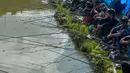 Para peserta pria berkonsentrasi dengan kailnya pada kompetisi memancing di sebuah kolam dekat desa Weilei di Negara Bagian Meghalaya, timur laut India, Sabtu (21/9/2019). Ratusan peserta berpartisipasi dalam kompetisi yang memperebutkan sejumlah hadia tersebut. (DIPTENDU DUTTA / AFP)