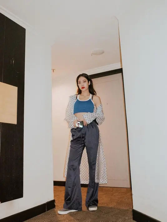 Gaya kasual manggung yang selalu tak terprediksi, kali ini Widi Vierratale pakai jas hujan polkadot, tank top cropped, dan celana berpotongan lebar. [IG@widikidiwdkdw]