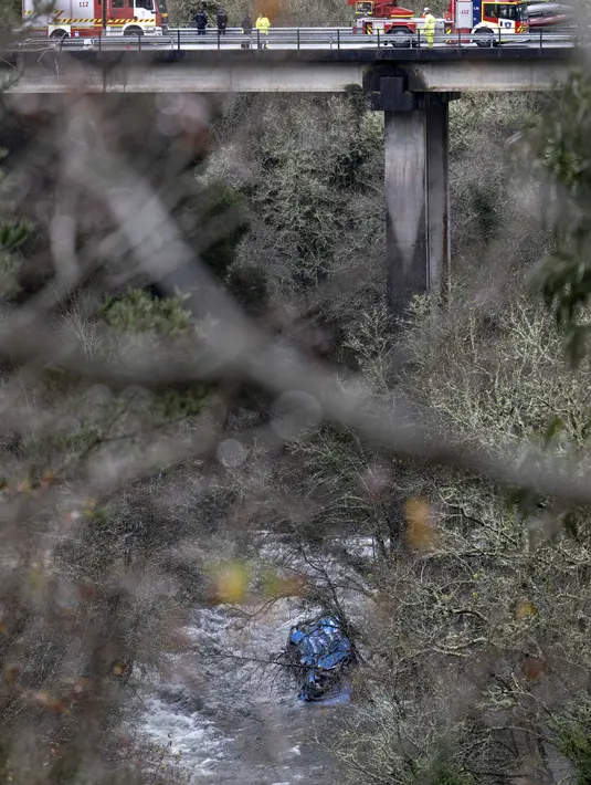 Bangkai bus terlihat di sungai Lerez setelah jatuh saat melintasi jembatan, menewaskan empat orang, di Cerdedo-Cotobade, Spanyol (25/12/2022). Kecelakaan itu terjadi pada 24 Desember malam di dekat Vigo dan perbatasan dengan Portugal. (AFP/Brais Lorenzo)