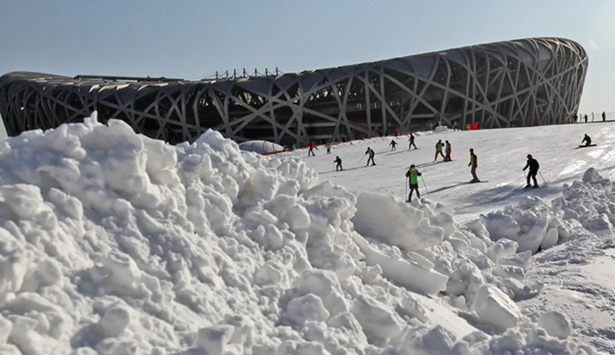 Warga bermain ski di antara lereng salju buatan di sekitar National Olympic Stadium, Tiongkok, Senin (2/1/2012). Meskipun minim salju namun sejumlah negara tetap memilih Beijing sebagai tuan rumah Olimpiade Musim Dingin 2022. (EPA/How Hwee Young)