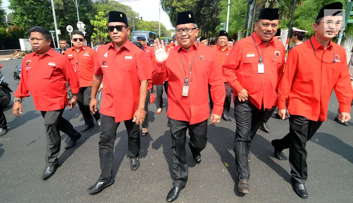 Sekretaris Jenderal PDIP Hasto Kristiyanto didampingi fungsionaris partai berjalan kaki menuju Kantor KPU, Jakarta, Rabu (11/10). PDIP membawa 5 boks berisi persyaratan untuk pendaftaran sebagai partai politik peserta pemilu. (Liputan6.com/Johan Tallo)